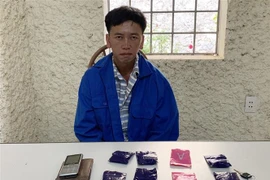 Đối tượng Giàng A Lự cùng tang vật tại cơ quan công an. (Ảnh: TTXVN phát) 