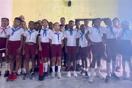 Đại sứ Việt Nam tại Cuba Lê Thanh Tùng và các em học sinh Cuba. (Ảnh: Mai Phương/TTXVN) 