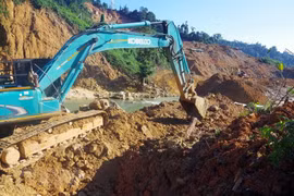 Các lực lượng cùng với phương tiện máy móc tích cực hoàn thành việc nắn dòng suối Rào Trăng trong ngày 21/11. (Ảnh: TTXVN phát)
