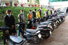 Các thanh thiếu niên cùng tang vật bị bắt giữ. (Ảnh: Thanh Tân/TTXVN) 