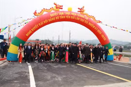 Ông Trần Quốc Vượng, Ủy viên Bộ Chính trị, Thường trực Ban Bí thư và lãnh đạo tỉnh Yên Bái cùng người dân trên cây cầu mới nối hai bên bờ sông Hồng. (Nguồn: TTXVNN) 