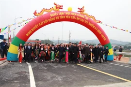 Ông Trần Quốc Vượng, Ủy viên Bộ Chính trị, Thường trực Ban Bí thư và lãnh đạo tỉnh Yên Bái cùng người dân trên cây cầu mới nối hai bên bờ sông Hồng. (Nguồn: TTXVNN) 