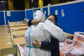 Bệnh nhân nhiễm COVID-19 tạm biệt bác sỹ sau khi được chữa khỏi tại bệnh viện ở Vũ Hán, tỉnh Hồ Bắc, Trung Quốc, ngày 9/3/2020. (Nguồn: THX/TTXVN) 