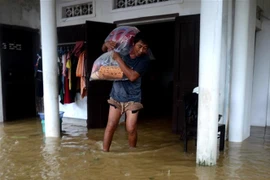 Người dân di dời đồ đạc đến vị trí cao ráo để tránh lũ. (Ảnh: Lê Ngọc Phước/TTXVN) 