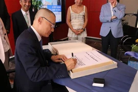 Đại sứ Vũ Quang Minh ghi sổ lưu niệm của thành phố Bühl. (Ảnh: Vũ Tùng/TTXVN)