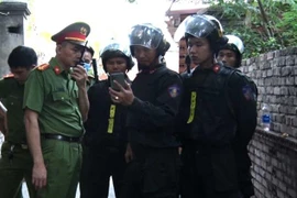 Lực lượng công an tại hiện trường giải cứu cháu bé hôm 5/9. (Nguồn: TTXVN phát) 