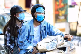 Đôi bạn trẻ dùng khẩu trang đeo lên trán để tránh cái nắng gay gắt (Ảnh chụp lúc 14 giờ ngày 1/6 ở Hà Nội). (Ảnh: Thành Đạt/TTXVN) 