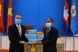 Đại sứ đặc mệnh toàn quyền Việt Nam tại Campuchia Vũ Quang Minh bàn giao quà tặng khẩu trang tới ông Kem Sambath, Ủy viên Trung ương Đảng, Phó Trưởng Ban Đối ngoại Trung ương CPP. (Ảnh: Hùng Vũ/TTXVN) 