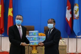 Đại sứ đặc mệnh toàn quyền Việt Nam tại Campuchia Vũ Quang Minh bàn giao quà tặng khẩu trang tới ông Kem Sambath, Ủy viên Trung ương Đảng, Phó Trưởng Ban Đối ngoại Trung ương CPP. (Ảnh: Hùng Vũ/TTXVN) 