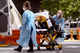 Nhân viên y tế chuyển bệnh nhân COVID-19 tại Melbourne, Australia. (Ảnh: AFP/TTXVN) 