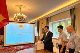 Cán bộ, nhân viên Đại sứ quán Việt Nam tại Ba Lan quyên góp ủng hộ đồng bào khắc phục hậu quả của cơn bão số 3. (Ảnh: TTXVN phát)