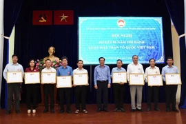 Ông Trần Hữu Phước, Phó Chủ tịch Ủy ban Mặt trận Tổ quốc Việt Nam Thành phố Hồ Chí Minh, tặng Bằng khen cho đại diện tập thể có thành tích trong thực hiện Luật Mặt trận Tổ quốc Việt Nam. (Ảnh: Xuân Khu/TTXVN) 