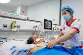 Nhân viên y tế Bệnh viện Quốc tế S.I.S Cần Thơ chăm sóc bà L.T.L. (Ảnh: TTXVN phát) 
