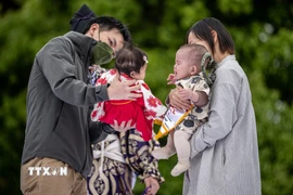 Cha mẹ cho các con tham gia một trò chơi ở Tokyo, Nhật Bản ngày 22/4/2023. (Ảnh: AFP/TTXVN)