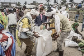 Người dân Ethiopia sơ tán tránh xung đột nhận bột mỳ cứu trợ từ Chương trình Lương thực Thế giới (WFP) tại trại tạm ở Debark, cách thành phố Gondar khoảng 90km, ngày 15/9/2021. (Ảnh: AFP/TTXVN) 