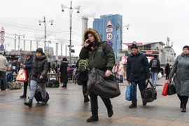 Người dân mang theo hành lý di chuyển gần nhà ga ở thủ đô Kiev, Ukraine ngày 24/2/2022. (Ảnh: AFP/TTXVN) 