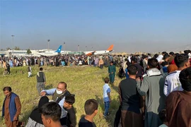 Hàng nghìn người dân Aghanistan đổ xô vào đường băng, cố lao lên các máy bay để rời khỏi đất nước sau khi Taliban tiếp quản quyền kiểm soát thủ đô Kabul, ngày 16/8/2021. (Ảnh: AFP/TTXVN) 