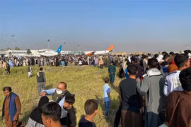 Hàng nghìn người dân Aghanistan đổ xô vào đường băng, cố lao lên các máy bay để rời khỏi đất nước sau khi Taliban tiếp quản quyền kiểm soát thủ đô Kabul, ngày 16/8/2021. (Ảnh: AFP/TTXVN) 