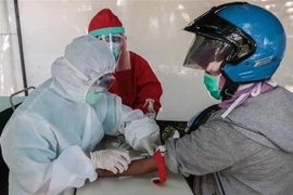 Nhân viên y tế xét nghiệm nhanh COVID-19 cho người dân tại Surabaya, Indonesia, ngày 22/4/2020. (Nguồn: THX/TTXVN) 