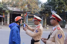 Cảnh sát giao thông kiểm tra nồng độ cồn người tham giao giao thông. (Ảnh: Quý Trung/TTXVN) 