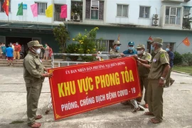 Lực lượng chức năng gỡ phong tỏa chung cư T23. (Ảnh: Văn Dũng/TTXVN) 