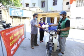 Tổ phòng, chống COVID cộng đồng kiểm tra giấy phép của người vận chuyển hàng hoá vào khu dân cư số 12, phường Bạch Mai, quận Hai Bà Trưng (ảnh chụp sáng 3/8/2021). (Ảnh: Hoàng Hiếu/TTXVN) 