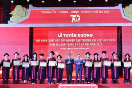 Ông Nguyễn Đắc Vinh, Ủy viên Trung ương Đảng, Chủ nhiệm Ủy ban Văn hóa, Giáo dục của Quốc hội và ông Nguyễn Văn Phong, Phó Bí thư Thành ủy Hà Nội trao Bằng khen của Chủ tịch Ủy ban Nhân dân Thành phố cho các thủ khoa xuất sắc tiêu biểu. (Ảnh: Minh Đức/TTXVN)