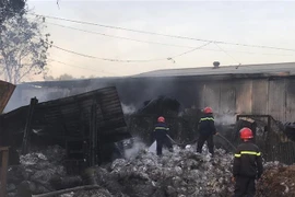 Lực lượng phòng cháy chữa cháy tiếp tục phun nước để tránh ngọn lửa bùng phát trở lại. (Nguồn: TTXVN phát) 