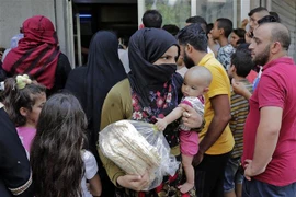 Người dân xếp hàng mua bánh mì tại Beirut, Liban. (Ảnh: AFP/TTXVN) 