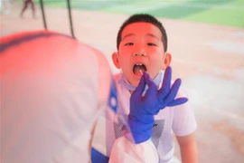 Lấy mẫu dịch xét nghiệm COVID-19 cho trẻ nhỏ tại Vũ Hán, tỉnh Hồ Bắc, Trung Quốc ngày 15/5/2020. (Nguồn: THX/TTXVN) 