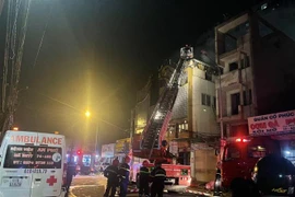 Cán bộ chiến sỹ công an phòng cháy chữa cháy và cứu hộ cứu nạn tiến sâu vào trong quán karaoke bị cháy để tìm kiếm thêm các nạn nhân. (Ảnh: Huyền Trang/TTXVN) 