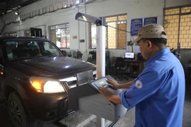 Đăng kiểm viên Trung tâm đăng kiểm xe cơ giới 1101S kiểm định xe cơ giới đường bộ. (Ảnh: Chu Hiệu/TTXVN)