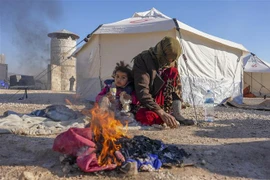 Người dân đốt lửa sưởi ấm trong thời tiết giá lạnh do bị mất nhà cửa sau trận động đất tại Jindayris, Syria, ngày 9/2/2023. (Ảnh: AFP/TTXVN) 