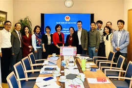 Đại sứ Lê Linh Lan trao khẩu trang của Chính phủ cho đại điện Hội Trí thức, chuyên gia Việt Nam tại Thụy Sĩ và Hội Thanh niên Việt Nam tại Thụy Sĩ. (Ảnh: Tố Uyên/TTXVN) 