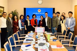 Đại sứ Lê Linh Lan trao khẩu trang của Chính phủ cho đại điện Hội Trí thức, chuyên gia Việt Nam tại Thụy Sĩ và Hội Thanh niên Việt Nam tại Thụy Sĩ. (Ảnh: Tố Uyên/TTXVN) 