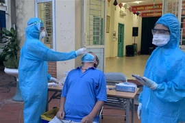Lực lượng y tế lấy mẫu xét nghiệm những người liên quan đến các ca dương tính ở phường Việt Hưng (quận Long Biên, Hà Nội). (Ảnh: Văn Cảnh/TTXVN)