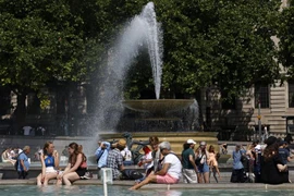 Người dân làm mát tại đài phun nước do nắng nóng gay gắt ở London, Anh ngày 17/6/2022. (Ảnh: AFP/TTXVN)