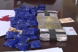 4 bánh heroin và 6.000 viên ma túy tổng hợp bị thu giữ. (Ảnh: TTXVN phát) 