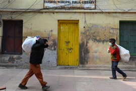 Người dân đeo khẩu trang phòng dịch COVID-19 tại New Delhi, Ấn Độ, ngày 16/1/2022. (Ảnh: AFP/TTXVN) 