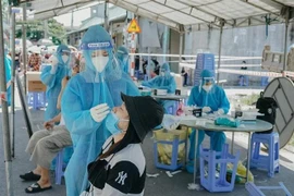 Lực lượng đoàn viên thanh niên thuộc Tỉnh đoàn Bình Dương hỗ trợ lấy mẫu xét nghiệm tìm F0 trong cộng đồng trên địa bàn thành phố Dĩ An, tỉnh Bình Dương. (Ảnh: Chí Tưởng/TTXVN) 