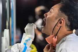 Nhân viên y tế lấy mẫu xét nghiệm COVID-19 cho người dân tại Thượng Hải, Trung Quốc. (Ảnh: AFP/TTXVN) 