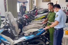 Tổ công tác kiểm tra xe bày bán tại cửa hàng Hữu Ý. (Ảnh: TTXVN phát) 