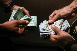 Người dân đổi tiền bảng Liban và tiền USD tại Beirut, Liban. (Ảnh: AFP/TTXVN)