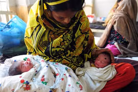 Bà mẹ chăm sóc hai bé sinh đôi tại bệnh viện ở Karachi, Pakistan. (Ảnh: AFP/TTXVN) 