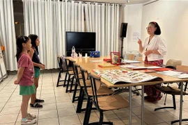 Bà Cấn Anh Claudine dạy Tiếng Việt cho các cháu bé. (Ảnh: Thu Hà/TTXVN)