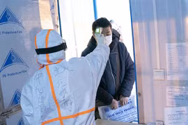 Nhân viên y tế kiểm tra thân nhiệt cho bệnh nhân nhiễm virus COVID-19 tại một bệnh viện dã chiến ở Vũ Hán, Trung Quốc ngày 5/2/2020. (Nguồn: THX/TTXVN) 