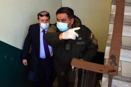 Bộ trưởng Y tế Bolivia Marcelo Navajas (trái) được áp giải tới phiên điều trần ở La Paz do liên quan tới bê bối mua máy trợ thở, ngày 20/5/2020. (Nguồn: AFP/TTXVN) 