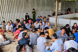 Các con bạc bị lực lượng công an bắt giữ. (Nguồn: TTXVN phát) 