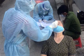 Xét nghiệm sàng lọc COVID-19 cho người dân phường Vĩnh Quang, thành phố Rạch Giá. (Ảnh: Lê Sen/TTXVN) 