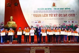 Trao tặng Bằng khen cho các học sinh là con, cháu thương binh, nạn nhân chất độc da cam/dioxin tiêu biểu, vượt khó vươn lên, giành kết quả xuất sắc trong học tập và rèn luyện, ngày 27/8/2017. (Ảnh: An Đăng/TTXVN) 